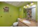 Bathroom featuring vanity with granite counter, toilet, and bright green walls at 19937 Gulf Blvd # B-3, Indian Shores, FL 33785