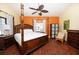 Bedroom with wood floors, four-poster bed, ceiling fan and bright natural light at 19937 Gulf Blvd # B-3, Indian Shores, FL 33785