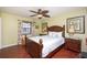 Cozy bedroom with wood floors, ceiling fan, and a window with floral curtains at 19937 Gulf Blvd # B-3, Indian Shores, FL 33785