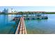 Waterfront view of a boat dock with boat lifts, boats, clear water, and residential buildings at 19937 Gulf Blvd # B-3, Indian Shores, FL 33785