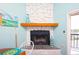 Close up of stone fireplace with light wood mantel, set up for dining near balcony at 19937 Gulf Blvd # B-3, Indian Shores, FL 33785