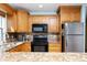Bright kitchen featuring granite countertops, wooden cabinets, and modern appliances at 19937 Gulf Blvd # B-3, Indian Shores, FL 33785