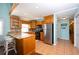 Open kitchen with stainless steel refrigerator, wooden cabinets, and breakfast bar seating at 19937 Gulf Blvd # B-3, Indian Shores, FL 33785