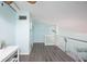 Bright open living space with updated flooring, ceiling fan, and glass railing overlooking the living area below at 19937 Gulf Blvd # B-3, Indian Shores, FL 33785