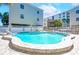 Inviting community pool with clear blue water, surrounded by lounge chairs and lush landscaping at 19937 Gulf Blvd # B-3, Indian Shores, FL 33785