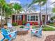 Inviting backyard with a brick fire pit, blue Adirondack chairs, and tropical landscaping create a relaxing outdoor space at 238 31St N Ave, St Petersburg, FL 33704