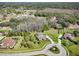 Picturesque aerial view of an estate surrounded by trees, featuring a circular driveway and a pool at 2659 Keystone Springs Rd, Tarpon Springs, FL 34688