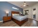 Comfortable main bedroom featuring wood floors, ceiling fan, accent wall and an ensuite bath and pool access at 2659 Keystone Springs Rd, Tarpon Springs, FL 34688