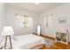 Bedroom with natural light showcases hardwood floors, white walls, sheer curtains, and a comfortable bed at 2660 Powell Ln, Tarpon Springs, FL 34688
