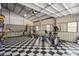 Spacious garage featuring checkered flooring and workout equipment at 2660 Powell Ln, Tarpon Springs, FL 34688