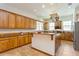 Spacious kitchen featuring wooden cabinets, tile flooring, a central island, and stainless steel appliances at 2660 Powell Ln, Tarpon Springs, FL 34688