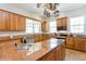 Bright kitchen with granite countertops, stainless steel appliances, wooden cabinets, and a functional island at 2660 Powell Ln, Tarpon Springs, FL 34688