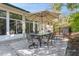 Outdoor patio with table, chairs, umbrella, and landscaped backyard at 2660 Powell Ln, Tarpon Springs, FL 34688
