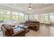 Bright sunroom with large windows, comfortable seating, and natural outdoor views at 2660 Powell Ln, Tarpon Springs, FL 34688