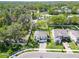 A sprawling aerial view showing the house and neighborhood, surrounded by mature trees and lush landscaping at 2911 Silva Wood Dr, Valrico, FL 33596