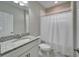 Well-lit bathroom with granite countertop, undermount sink and a shower with curtain at 2911 Silva Wood Dr, Valrico, FL 33596