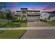 Elegant two-story home featuring a three-car garage, lush landscaping, and a paver driveway at 2911 Silva Wood Dr, Valrico, FL 33596
