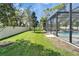 An inviting view of the screened enclosure and a section of the backyard at 2911 Silva Wood Dr, Valrico, FL 33596