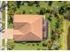 Aerial view of the home showing a tiled roof, screened-in patio, and mature landscaping at 317 Cockle Shell Loop, Apollo Beach, FL 33572