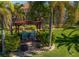 Charming backyard with a pergola, fire pit, and lush tropical landscaping at 317 Cockle Shell Loop, Apollo Beach, FL 33572