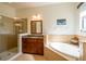 Bright bathroom featuring a soaking tub, double vanity, and separate glass shower at 317 Cockle Shell Loop, Apollo Beach, FL 33572