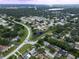 An aerial view of a neighborhood featuring tree lined streets and a community pond at 3184 Cypress Green Dr, Palm Harbor, FL 34684