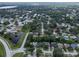 An aerial view of a neighborhood with mature trees and a pond at 3184 Cypress Green Dr, Palm Harbor, FL 34684