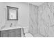 Bathroom features a marble countertop, cabinet, and tiled shower at 3184 Cypress Green Dr, Palm Harbor, FL 34684