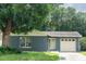 Charming single-story home featuring a well-maintained lawn, mature trees, and an attached garage at 3184 Cypress Green Dr, Palm Harbor, FL 34684