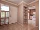Welcoming entryway featuring tile floors, built-in shelving, and a view into the kitchen at 4031 Bluff Oak Ct, Palm Harbor, FL 34684