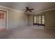 Spacious living room features a ceiling fan, neutral carpet and sliding glass door to outside at 4031 Bluff Oak Ct, Palm Harbor, FL 34684