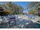 Inviting pool area with tables and chairs surrounded by lush landscaping and mature trees under a bright blue sky at 4031 Bluff Oak Ct, Palm Harbor, FL 34684