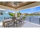 An outdoor dining area with seating and a stunning waterfront view from the home's covered balcony at 48 Sandpiper Rd, Tampa, FL 33609