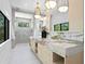 Bright bathroom featuring a double vanity, marble counters, stylish lighting, and a glass enclosed shower at 48 Sandpiper Rd, Tampa, FL 33609