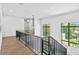 A bright hallway featuring hardwood floors, modern railings, large windows, and contemporary lighting at 48 Sandpiper Rd, Tampa, FL 33609