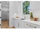 Well-lit kitchen with white cabinetry, marble countertops, stainless steel faucet, and convenient pantry access at 48 Sandpiper Rd, Tampa, FL 33609