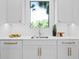 Bright kitchen showcasing white cabinets, marble countertops, sleek faucet, and functional under-cabinet lighting at 48 Sandpiper Rd, Tampa, FL 33609