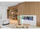 Stylish living room featuring wood paneled wall and custom built-ins surrounding a modern fireplace at 48 Sandpiper Rd, Tampa, FL 33609