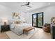 Bright main bedroom with a king bed, stylish bench, access to a balcony and elegant decor at 48 Sandpiper Rd, Tampa, FL 33609