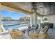 Inviting waterfront patio with elegant seating, ceiling fans, and a pristine pool overlooking tranquil canal views at 48 Sandpiper Rd, Tampa, FL 33609