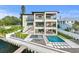 Stunning waterfront home with an infinity pool, integrated hot tub, and covered outdoor seating areas at 48 Sandpiper Rd, Tampa, FL 33609