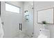 Modern shower with white subway tile, black hardware, glass enclosure, and window at 48 Sandpiper Rd, Tampa, FL 33609
