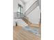 A modern staircase with wood steps and sleek black railings, complemented by natural light and elegant stone accents at 48 Sandpiper Rd, Tampa, FL 33609