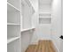 A well-organized walk-in closet with custom shelves and wooden flooring, providing ample storage space at 48 Sandpiper Rd, Tampa, FL 33609