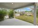 Spacious back patio with a view of the lush backyard, mature trees, and additional storage sheds at 5134 Jenson Ave, Spring Hill, FL 34608