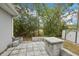 Backyard patio features a decorative stone half-wall and access to a shed with green views at 5134 Jenson Ave, Spring Hill, FL 34608