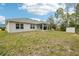 Expansive backyard featuring lush green lawn, a covered patio, and additional storage shed at 5134 Jenson Ave, Spring Hill, FL 34608
