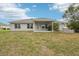 Spacious backyard showcases the home's covered patio, well-maintained lawn, and decorative stone accents at 5134 Jenson Ave, Spring Hill, FL 34608