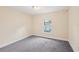 Cozy bedroom with neutral walls and gray carpet with a window overlooking the yard at 5134 Jenson Ave, Spring Hill, FL 34608