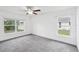 Bright bedroom features a ceiling fan, two large windows, and neutral decor at 5134 Jenson Ave, Spring Hill, FL 34608